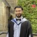 Photo of student Hashemipour on his graduation day, standing in front of an old college