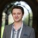 Head and shoulders portrait of a student Koubis, with blurred archway in the background in an outdoor setting