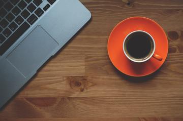 Image of a cup of coffee and a laptop