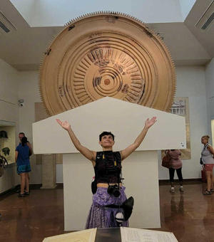 Student Barton raising hands up in the air at the museum