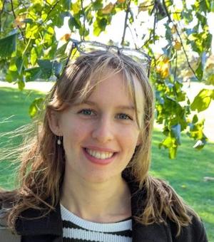 Headshot of student Hickes smiling. It's a sunny day.