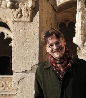 Student Ruin standing and smiling, in a location with some historical significance 